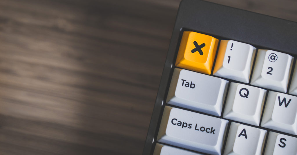Computer keyboard with bright yellow x button.